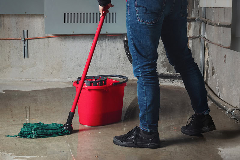 a man mopping up flooded basement.